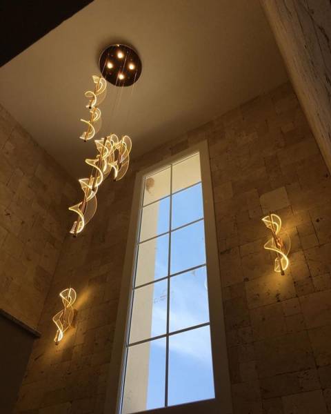 Installation de luminaires et suspensions modernes pour une montée d’escaliers haut plafond à Fontaines sur Saône près de Lyon