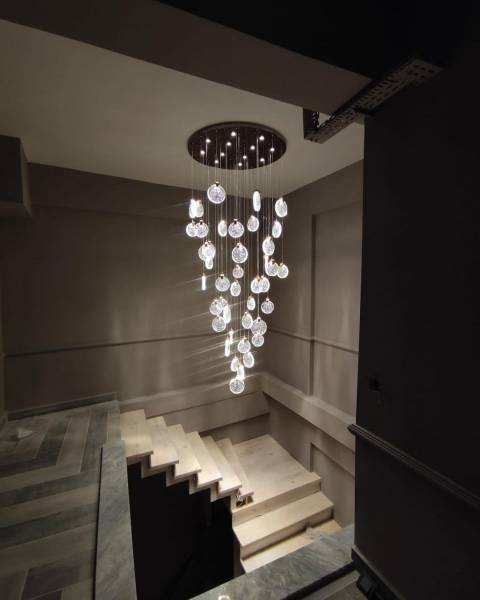 Réalisation de suspension moderne pour une cage d'escalier plafond haut à Champagne au Mont d'Or dans l’ouest lyonnais